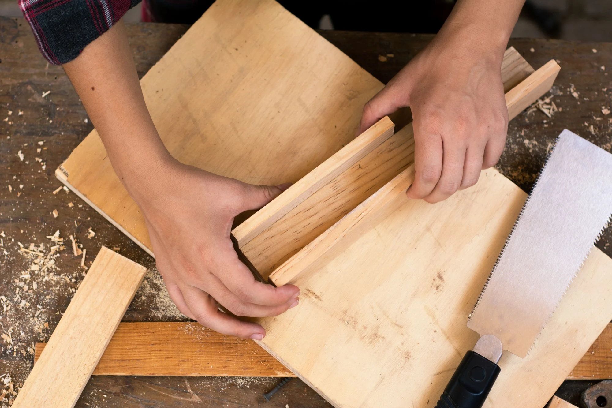 Hands carefully working with wood and carpentry tools